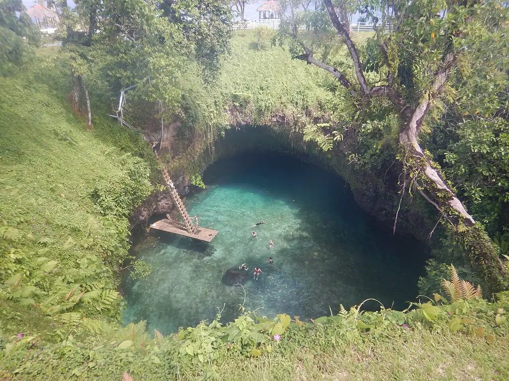 Piscina natural volcánica de unos 30 metros de profundidad en la costa sur de Upolu, a la que se desciende por una escalera entre vegetación exuberante.