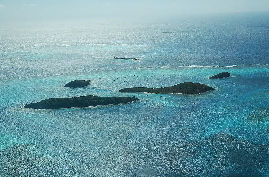 Archipiélago de islotes deshabitados rodeados de arrecifes de coral y aguas turquesa, con tortugas marinas que se pueden ver nadando en su hábitat natural.